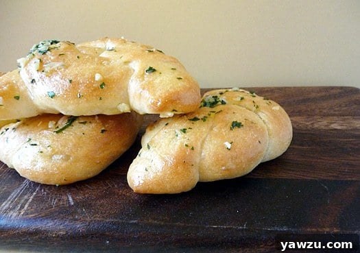 Three golden-brown garlic knots, perfectly baked and ready to enjoy.