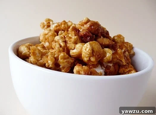 Homemade Cracker Jack popcorn in a white bowl, glistening with caramel.