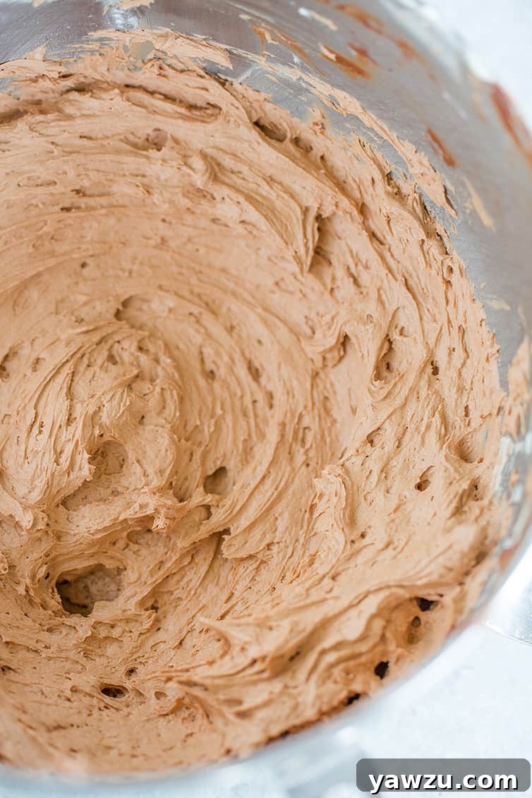 A mixing bowl with chocolate frosting in it.