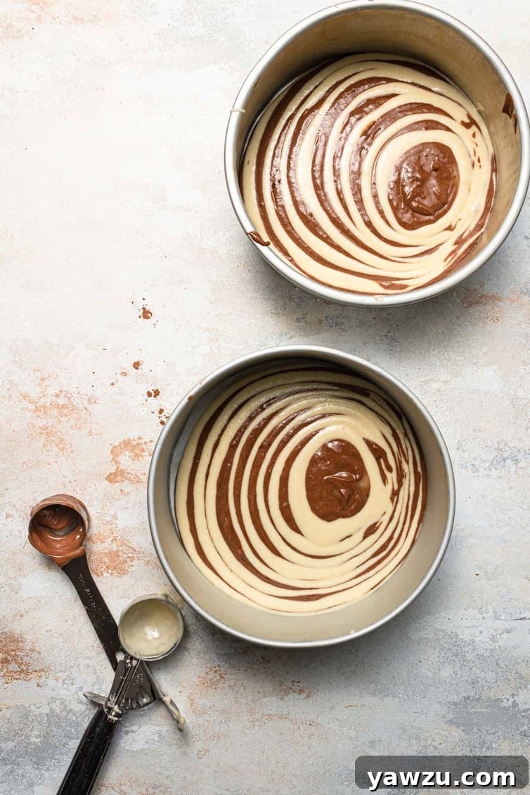 Cake pans filled with zebra cake batter.
