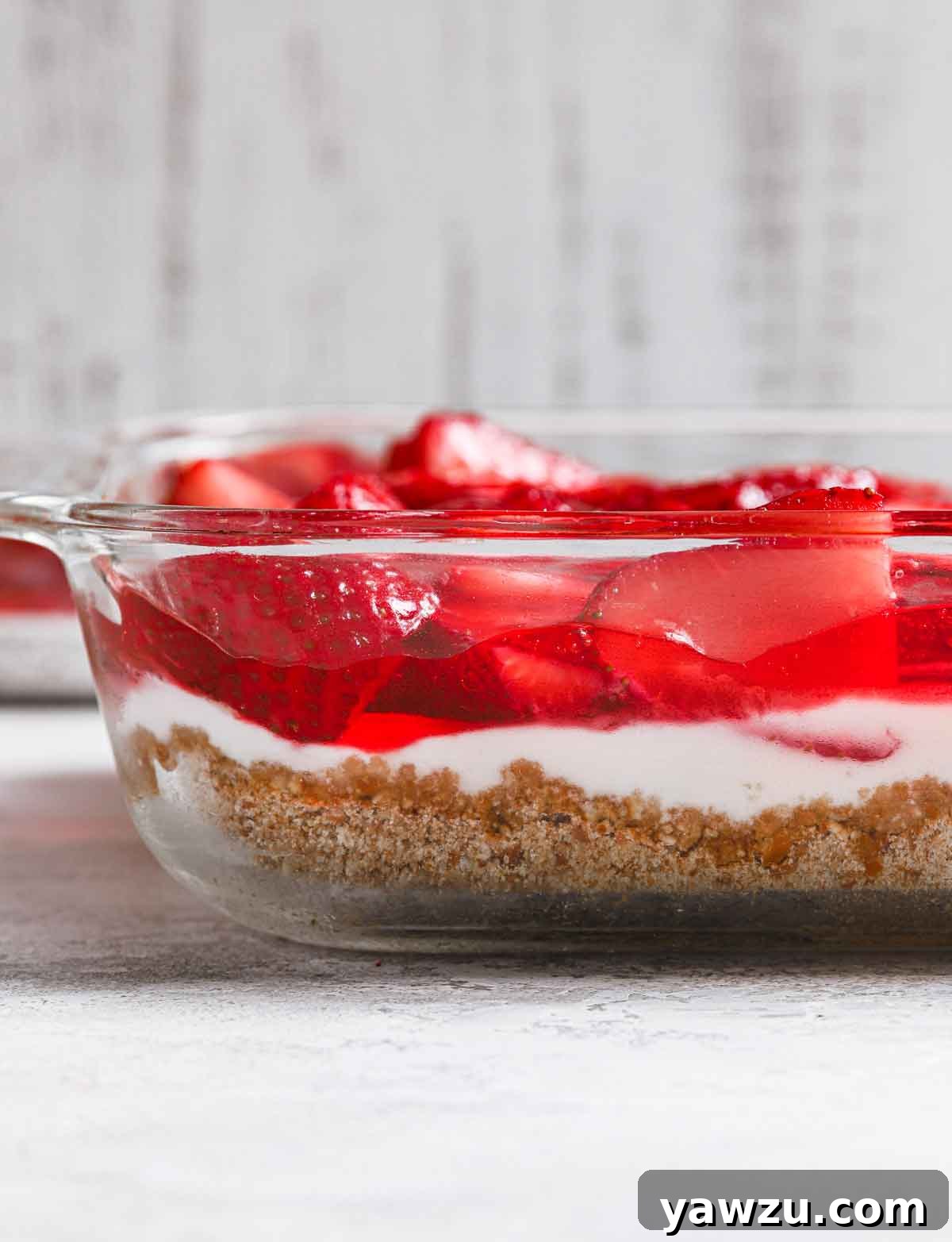 Side view of strawberry pretzel salad in a glass baking dish.