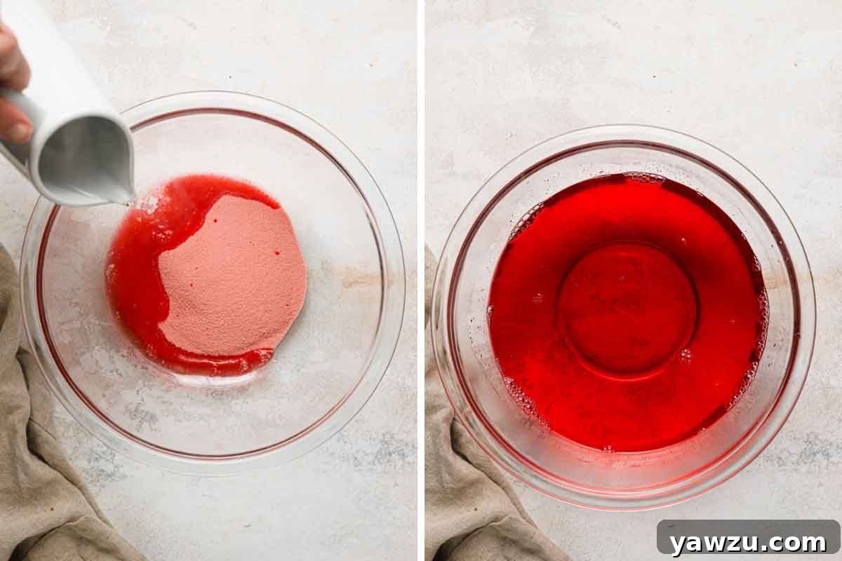 Strawberry Jello being dissolved in a glass bowl with hot water.
