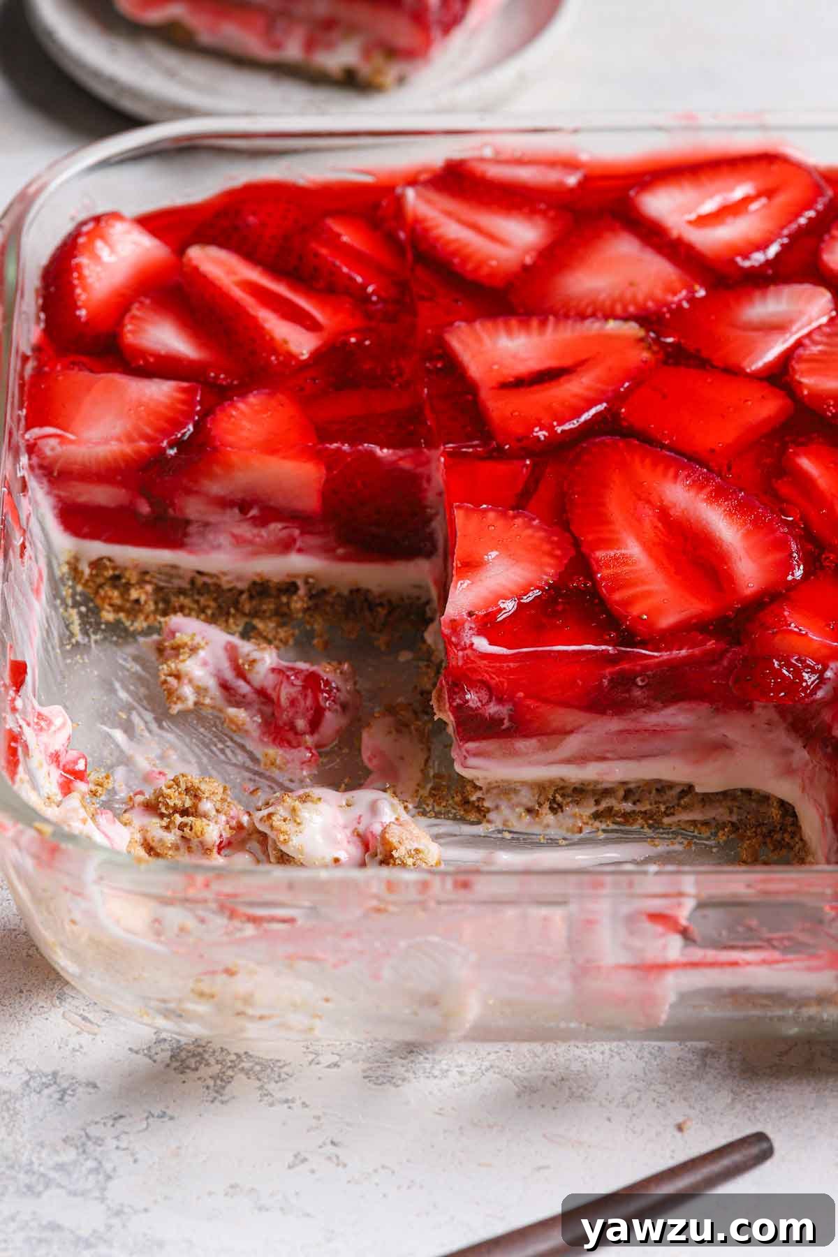 Photo of strawberry pretzel salad in a glass baking pan with a few slices removed.
