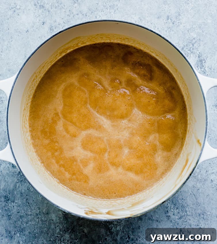 A pot on the stove with butter and peanut butter boiling together, the initial step for easy fudge.